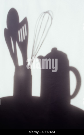 Shadow in warm light on pale cloth or curtain of coffee pot and kitchen utensils in jar Stock Photo