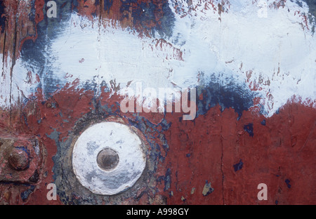 Close up of graphic and abstract design on side of boat or vehicle or machine caused by flaking paint and touching up Stock Photo