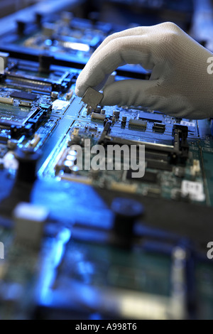 Manual Hand placed Components Printed Circuit Board Manufacturing view along assembly belt blue gel Stock Photo