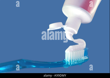 Blue Toothbrush and toothpaste on a blue background Stock Photo