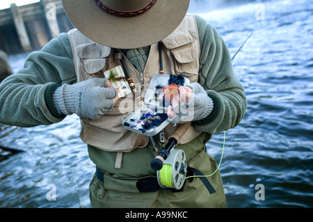 Man baiting hook while fly fishing in a river Stock Photo - Alamy