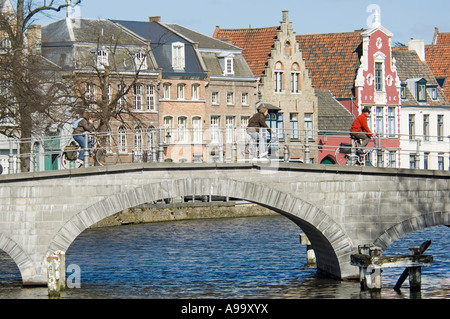 Two cyclist crossing one of the many picturesque bridges in the old city of Bruges (Brugge), Belgium. Stock Photo