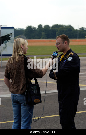 Television or newspaper journalist with a microphone interviewing a ...