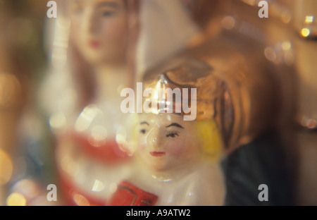 Close up of a china model of the Virgin Mary sitting on a throne with a crowned infant Jesus Christ in warm light Stock Photo