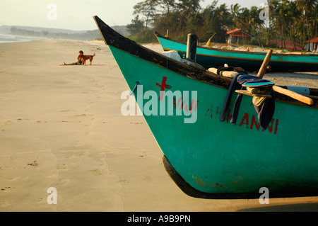 Man with dog practicing yoga on Mandrem Beach,Goa,India Stock Photo