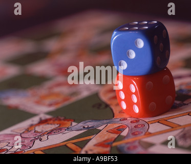 Dice on a game of snakes ladders Stock Photo