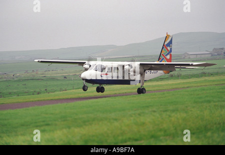 Britten Norman Islander aircraft lands on a grass strip on the Orkney Island of North Ronaldsay Stock Photo