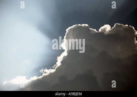 Sunrays bursting from behind clouds Stock Photo