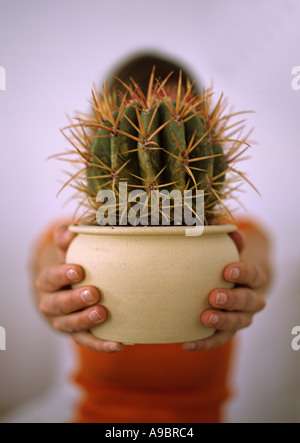 woman holding a spiny cactus Stock Photo