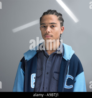A young African American man, in his late teens pose with a letterman's jacket. Stock Photo