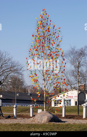 Birch treee with colorful feathers as an easter decoration in a roundabout in Nyköping Sweden Stock Photo