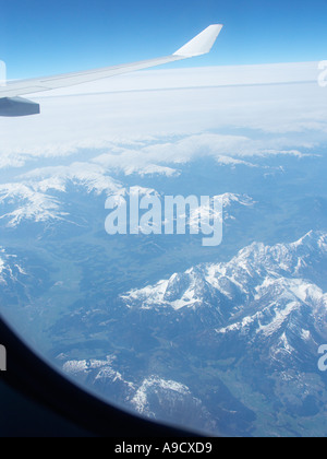 view from passenger aircraft window flying over mountains Stock Photo