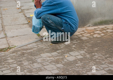 Men sitting on their haunches Stock Photo - Alamy