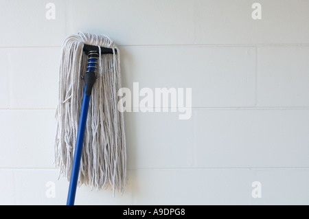 old fashioned rope mop leaning against wall Stock Photo