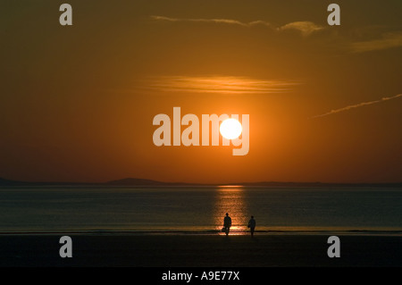 Family on beach at Broadhaven at sunset Pembrokeshire Dyfed West Wales ...