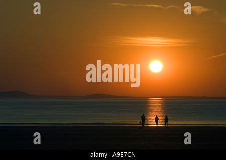 Family on beach at Broadhaven at sunset Pembrokeshire Dyfed West Wales ...