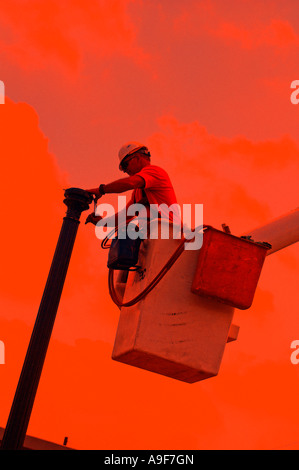 electric utility lineman linemen working in boom truck Stock Photo