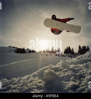 snowboarder snowboarding on half pipe jumping through air pulling of a grab Stock Photo