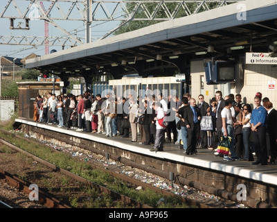 Crowd of people on Stratford train station platform rubbish & weeds on track before becoming major transport infrastructure site for London 2012 UK Stock Photo