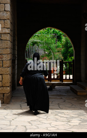 Nun in a black frock entering Saint Nicolas Monastery Monastery religious worship worshiper Stock Photo