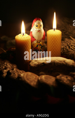 chocolate Santa Claus in the candlelight of beeswax candles Stock Photo