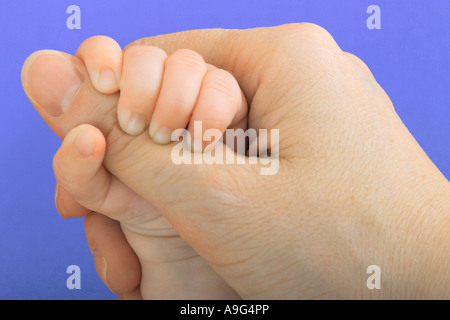 Baby grabbing mothers thumb Stock Photo