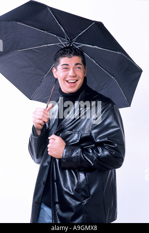 young man with umbrella, wearing leather jacket Stock Photo