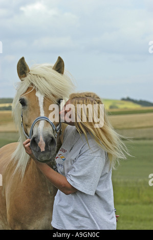 Haflinger horse (Equus przewalskii f. caballus), with blond woman Stock Photo