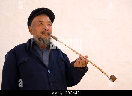 Elderly man with bamboo pipe in Baisha Village near Lijiang, Yunnan province, China Stock Photo