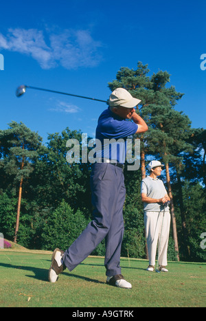 golfers model released teeing off Surrey England UK Stock Photo