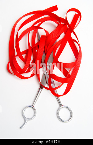 Cutting red tape with scissors Stock Photo