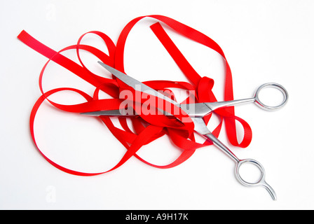 Cutting red tape with scissors Stock Photo
