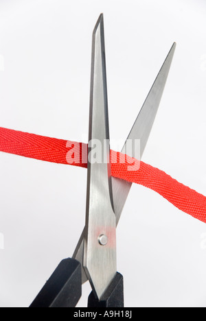 Scissors cutting through red tape Stock Photo