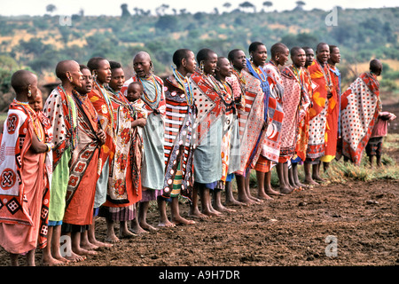 Masai women perform a traditonal welcome for tourists visiting their village manyatta in the Masai Mara in Kenya. Stock Photo