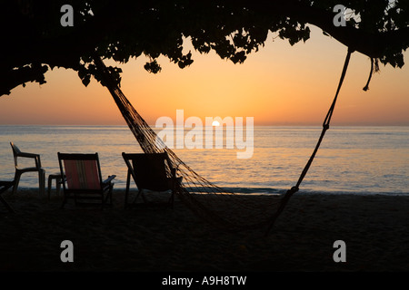 Beach hammock in The Maldives with the sun setting in the background Stock Photo
