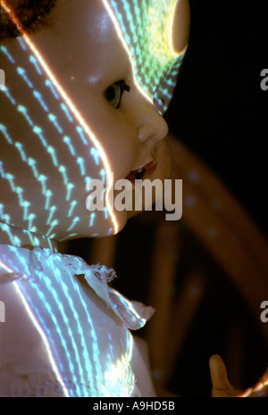 Scary doll in the dark with patterned light shining on its face Stock Photo