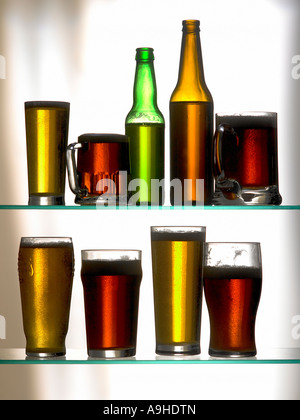 two rows of beer bottles and tankards Stock Photo