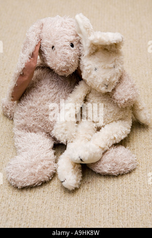 Two stuffed toy rabbits in an embrace Stock Photo