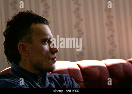 worried man sitting on the couch Stock Photo