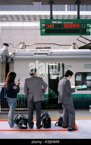 Commuters wait for the departure of their Shinkansen train at Tokyo Station. Stock Photo