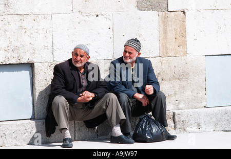 Two Turkish men sitting chatting Konya Central Anatolia Turkey Seated outside the Dervish museum Stock Photo