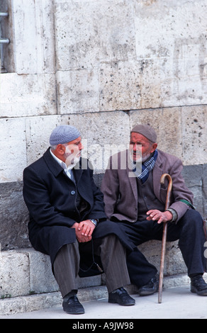 Two Turkish men sitting chatting Konya Central Anatolia Turkey Seated outside the Dervish museum Stock Photo
