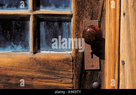 Detail of wood door with glass panes and marble door knob Bodie State Historic Park National Historic Landmark California Stock Photo