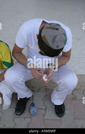 Young Jewish man writing on an egg for fertility during the Lag B’Omer festival at the La Griba synagogue Djerba Stock Photo