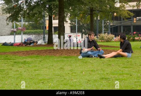 Male and Female Student (age 18 - 20) talking while relaxing in a park in Atlanta, Georgia, USA. Stock Photo