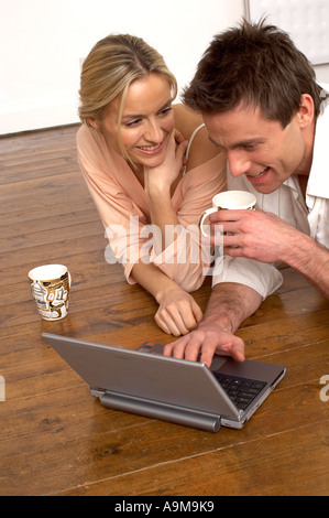 couple using a laptop while drinking coffee Stock Photo