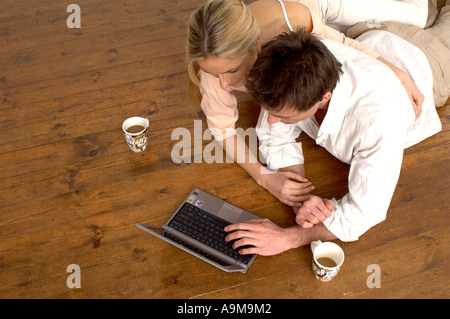 couple using a laptop while drinking coffee Stock Photo