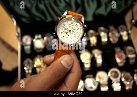 A man prays near knock-off luxury watches displayed by sellers along  News Photo - Getty Images