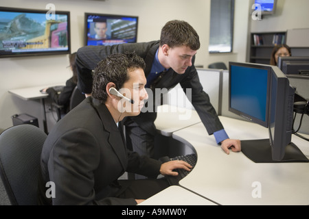 Co-workers in an office looking at a computer screen Stock Photo