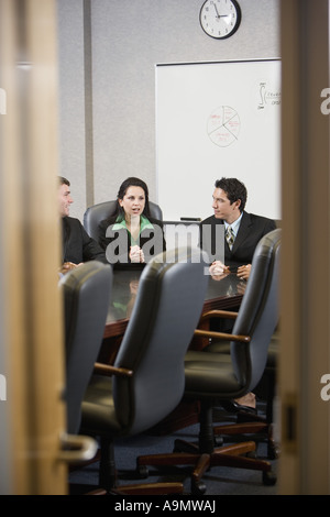 Business executives meeting in a conference room viewed through a door Stock Photo